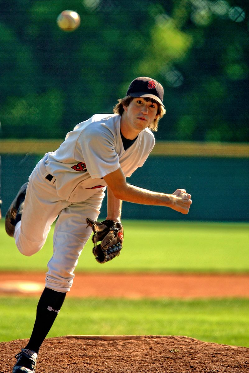 A young pitcher mid-throw on the mound
